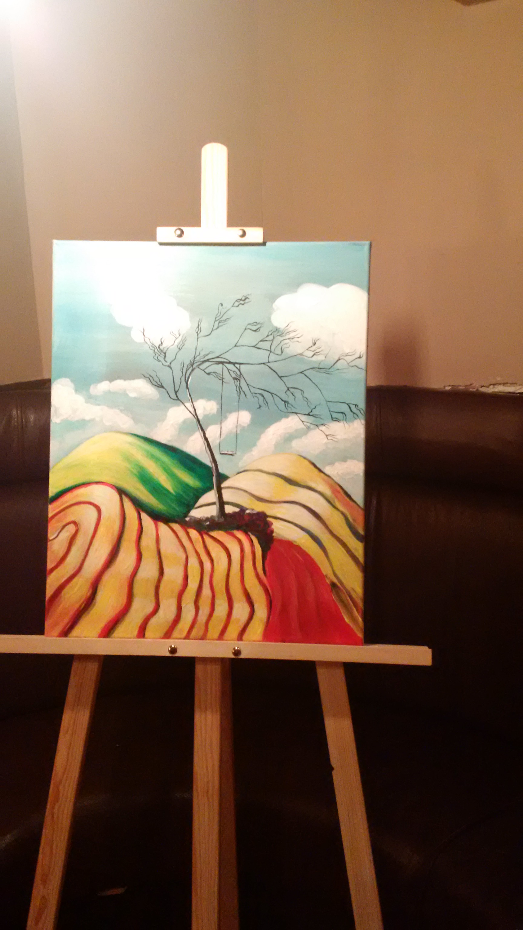 A tree without leaves in an undulating red and yellow field